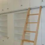 Hohes Schrankmöbel im Bürobereich mit Leiterprofil und Leiter